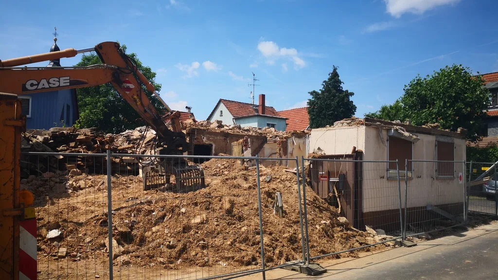 Abbruch eines Bestandsgebäudes mit Bagger im Ortskern
