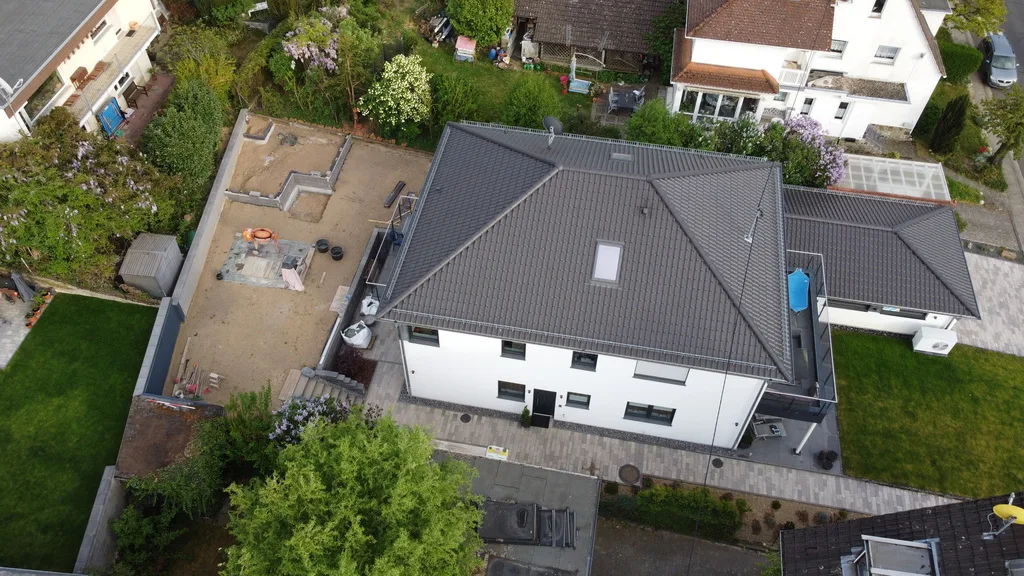 Schräge Luftaufnahme eines fertiggestellten Einfamilienhauses mit Anthrazitdach