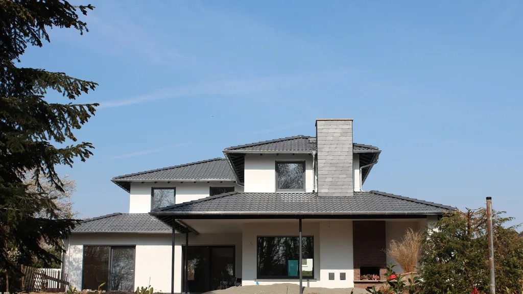 Fertiggestelltes Einfamilienhaus mit Walmdach und Putzfassade
